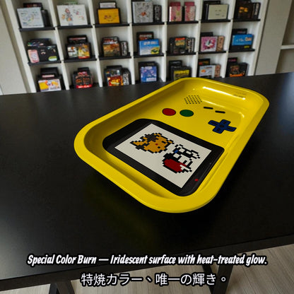 Yellow tray with pixelated design on a black surface, with shelves of video games in the background.